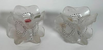 two glass vases with flowers on them on a table