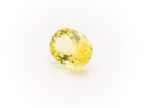 a yellow sapphire stone on a white background