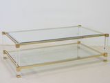 une table basse en verre et en laiton avec un plateau en verre