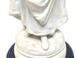 a statue of a man with a hat and robe on a pedestal