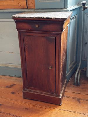 une armoire en bois avec un plateau en marbre, posée sur un parquet
