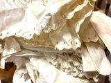 a pile of folded white cloth on a wooden chair