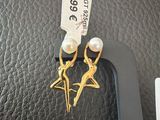 a picture of a pair of earrings that are on top of a purse