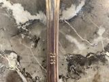 a silver spoon with a gold handle on a marble surface