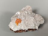 a small piece of rock with a piece of orange on it