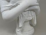 a white statue of a woman holding a flower in her hand
