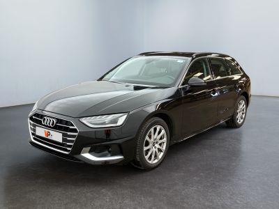 Une Audi noire est garée dans une pièce aux murs blancs