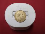 a close up of a gold coin on a red surface