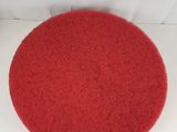 the red round rug is sitting on a white surface