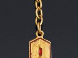 an image of a gold necklace with a red stone on it