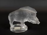 une sculpture en verre représentant un ours, posée sur un socle transparent