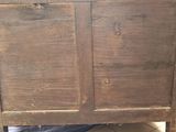 a very old wooden bed with a drawer underneath it