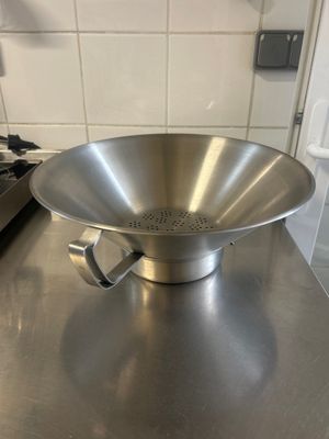 a large metal bowl sitting on a counter in a kitchen