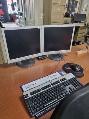 deux écrans d'ordinateur et un clavier sur un bureau