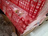 a red basket full of empty plastic bottles on the floor