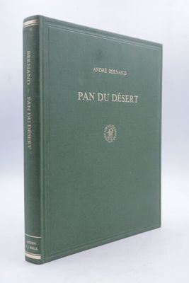 un vieux livre à la couverture verte posé sur une table blanche