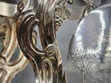 a person holding a silver plate with a bird on it