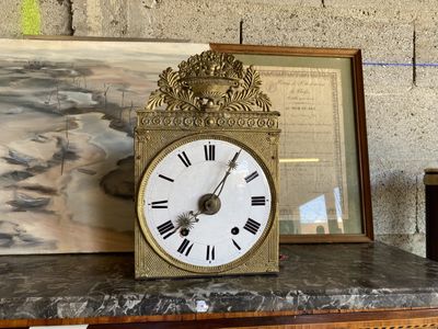 une horloge posée sur une table, à côté d'une photo encadrée