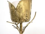 a gold vase with a flower on it on a table
