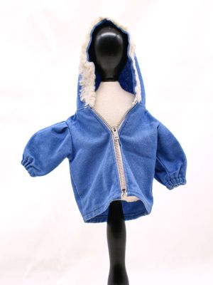 une petite poupée portant une veste bleue à capuche