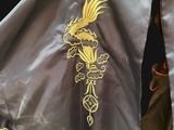 two jackets with gold embroiderys on them on a black background