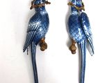 une paire de figurines de perroquets bleus posées sur une table blanche