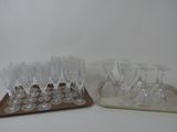 bottles and glasses on a tray on a white surface