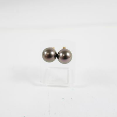 paire de boucles d'oreilles à clous en perles noires, présentées sur un support en acrylique transparent