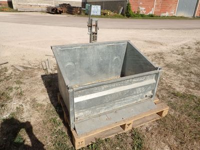 une caisse métallique posée sur une palette dans l'herbe