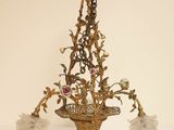 un lustre d'où pendent des fleurs, posé sur une table blanche