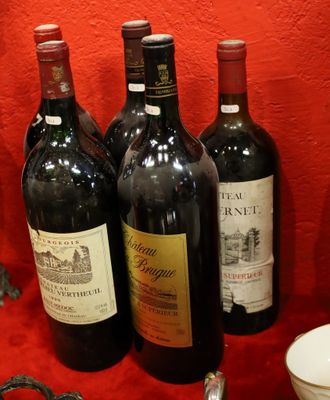 several bottles of wine are lined up on a red table