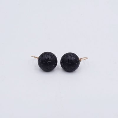 boucles d'oreilles en perles d'onyx noir sur fond blanc