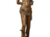 bronze statue of a woman holding a knife on a wooden base