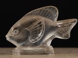 a clear glass fish figurine on a wooden table