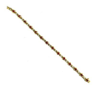 a close up of a gold bracelet with red stones on it
