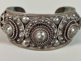 a close up of a silver bracelet on a white surface