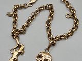 an image of a gold chain bracelet with two charms on it