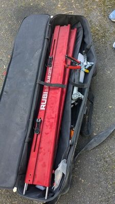un sac posé par terre, contenant un objet rouge