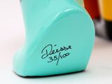a close up of a blue vase with a name on it