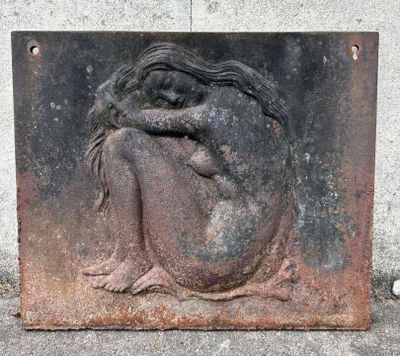 une sculpture représentant une femme assise par terre
