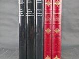 three red and black books sitting next to each other on a table
