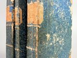 un vieux livre à la couverture bleue posé sur une surface blanche