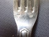 a silver fork that is sitting on top of a table