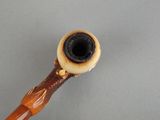 a pipe with a wooden handle on a gray surface