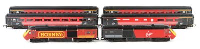 three red and yellow trains sitting side by side on a white surface
