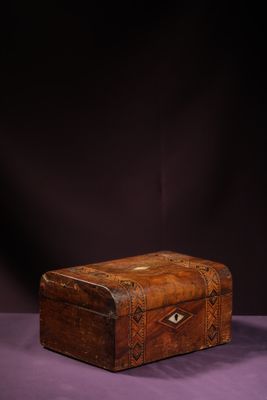 an old wooden box sitting on top of a purple surface