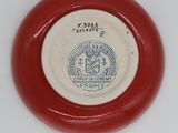 a red and white plate with a seal on it