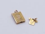 a close up of a small book and a small book charm on a white surface