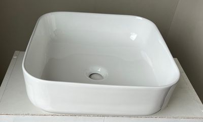 a white square sink sitting on top of a white counter
