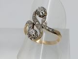 un gros plan d'une bague en or et diamants présentée sur un présentoir transparent